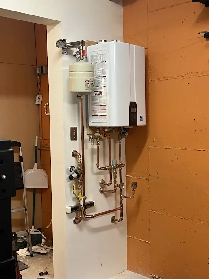 Plumbing technician inspecting water heater connections in Mountain Grove